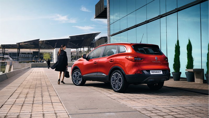 Renault KADJAR - Véhicule rouge garée devant un bâtiment moderne